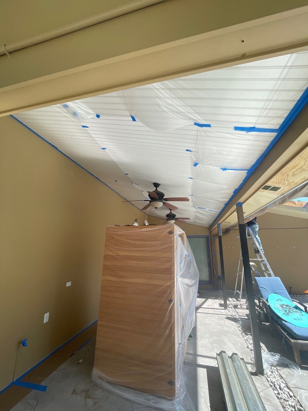 Highmark Painters and Handymen prep work in progress, with patio ceiling masked with protective plastic and painter's tape before exterior painting in Dunedin Florida